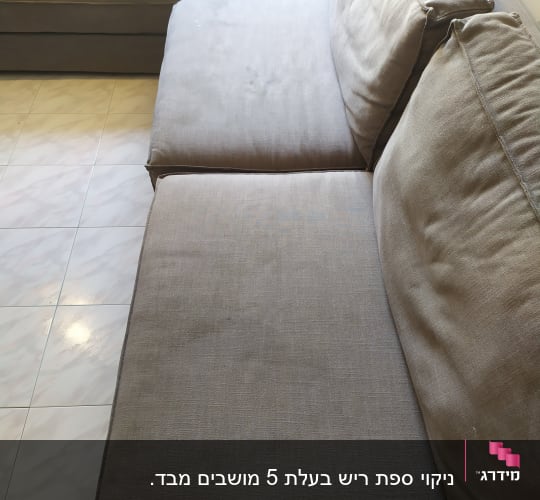 ספה אפורה עם כריות על רצפת אריחים